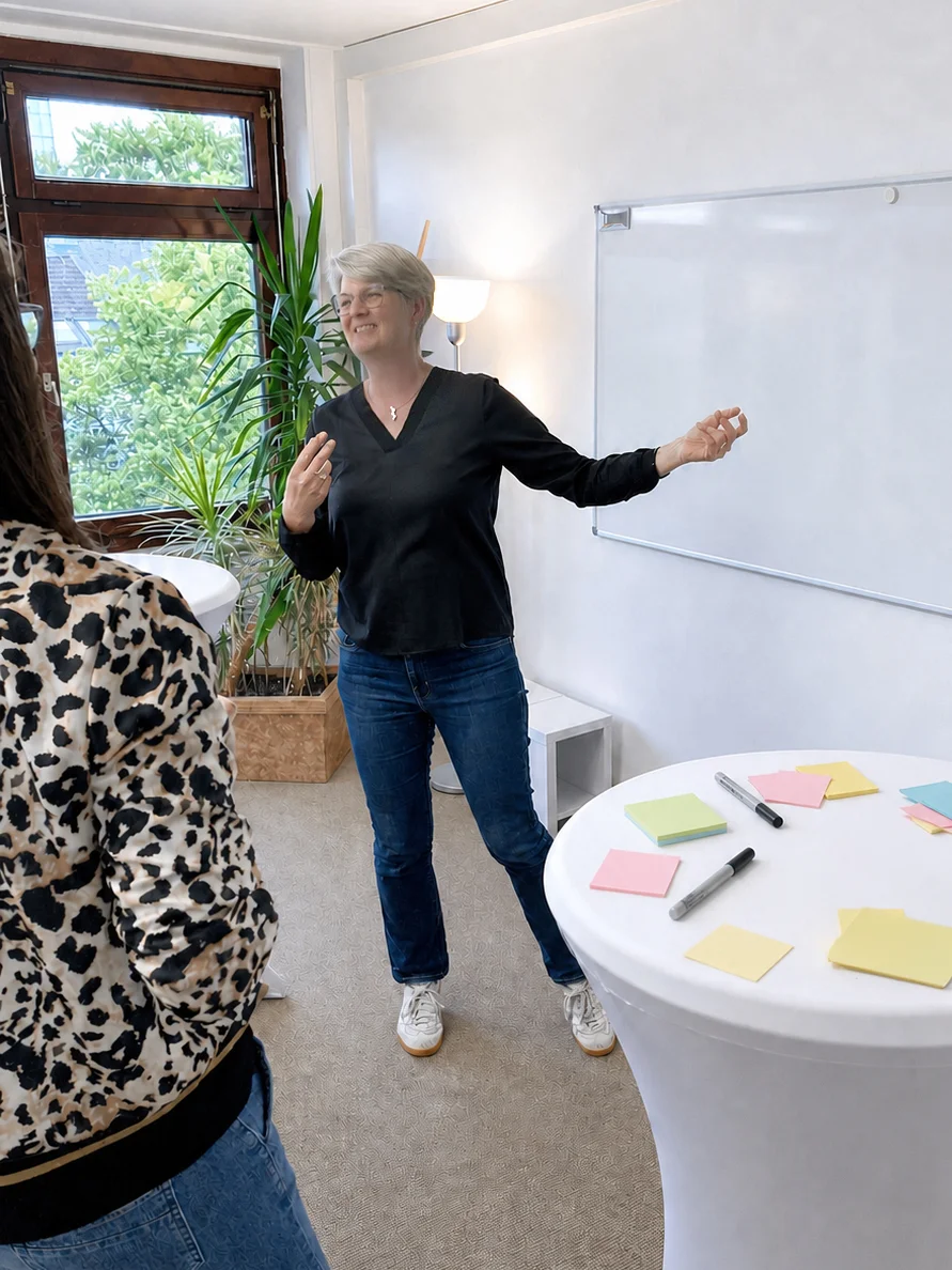 Anne Komp, stehend, bei einer Teamberatung